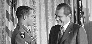 For “extraordinary heroism and risk of life,” SFC Adderly was awarded the Distinguished Service Cross (DSC) from President Richard M. Nixon during a White House ceremony on 25 November 1970. This was only four days after the raid into North Vietnam. COL Simons, left, was also awarded the DSC by the President.