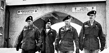 Soldiers assigned to the 10th Special Forces Group wear the unit’s Trojan Horse Badge just outside of the gates at Bad Tölz, Germany soon after the unit adopted the badge. From left to right is MSG Ernest E. Emmons, SFC Kenneth W. Gibson, SFC William F. Whitehead, and SFC Bertsy M. Goodson.