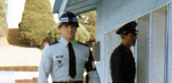 In Korea, then-SSG Lamb began his tour of duty in 1984, and was handpicked for the UN Command Security Group, Joint Security Area, Panmunjom. In this photo, Lamb is on the south side of the Military Demarcation Line (MDL) with a North Korean soldier on the north side. The white building is one of a series used for armistice talks, ongoing to this day since 1953.