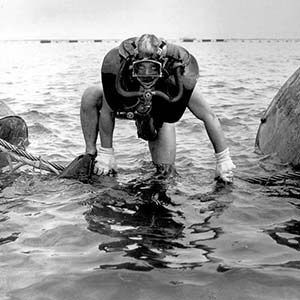 Operational Swimmer from Group II wearing LARU Model 10 climbing over Torpedo Net Defenses in Guantanamo Bay Cuba, Sept. 1944.