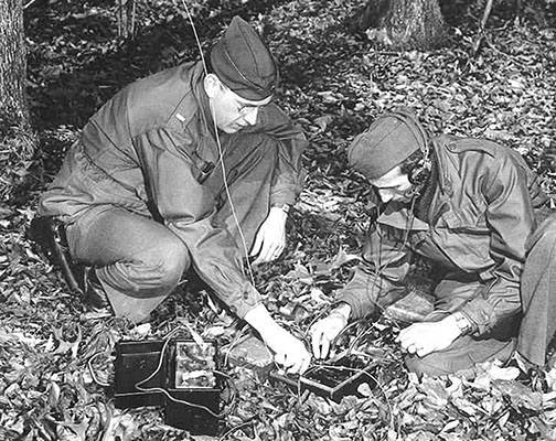 A Communications Branch instructor demonstrates a radio to an OSS recruit at Area C.