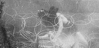 An MU swimmer negotiates anti-submarine concertina wire nets during underwater training.