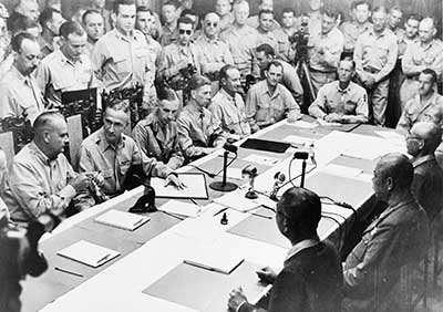 1945 SEP 03: Seated (far right) at table during formal surrender of all Japanese armed forces in the Phillipines at Baguio, Phillipnes.